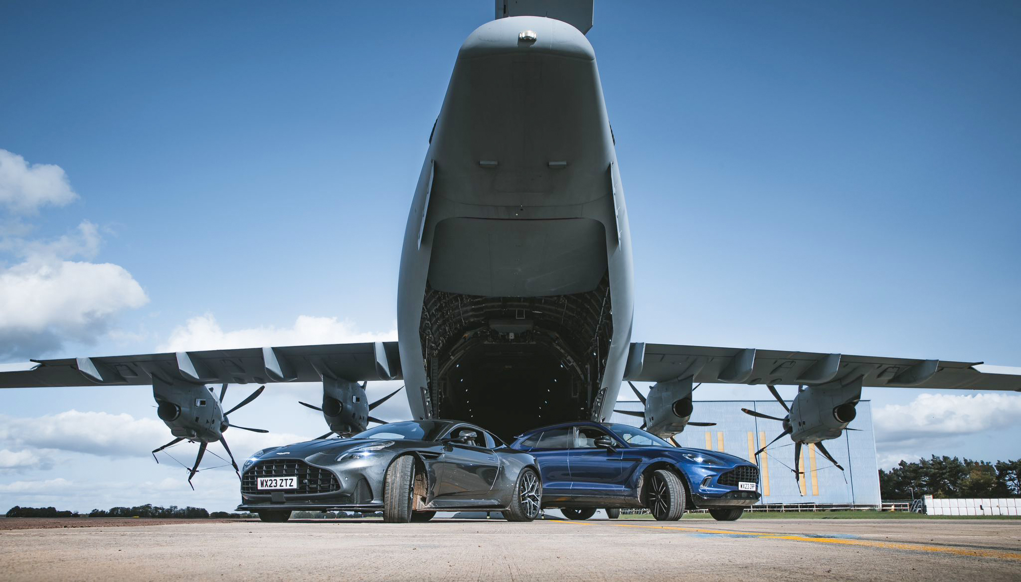 Photo - Two Aston Martin vehicles lined-up behind an Atlas C Mk.1 (A400M)
